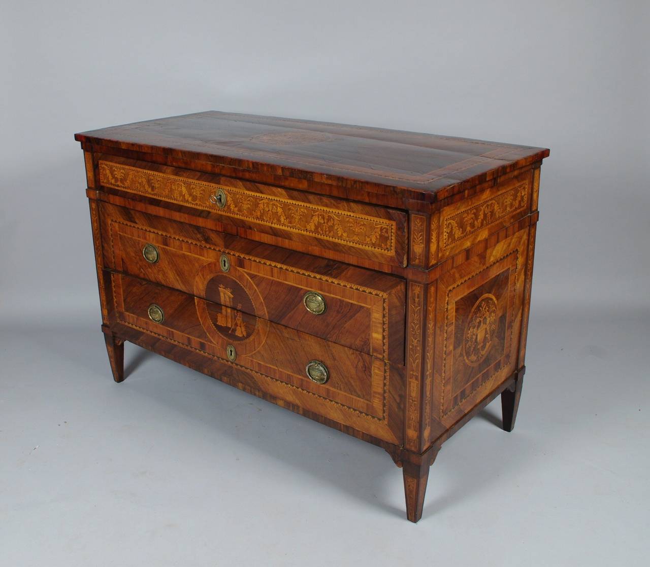 Fine Milanese marquetry commode attributed to Gaspare Basanni, the rectangular top of quarter matched rosewood veneers with tulipwood and acanthus crossbanding, centered by an elaborate leaf and foliate medallion; the upper drawer with running