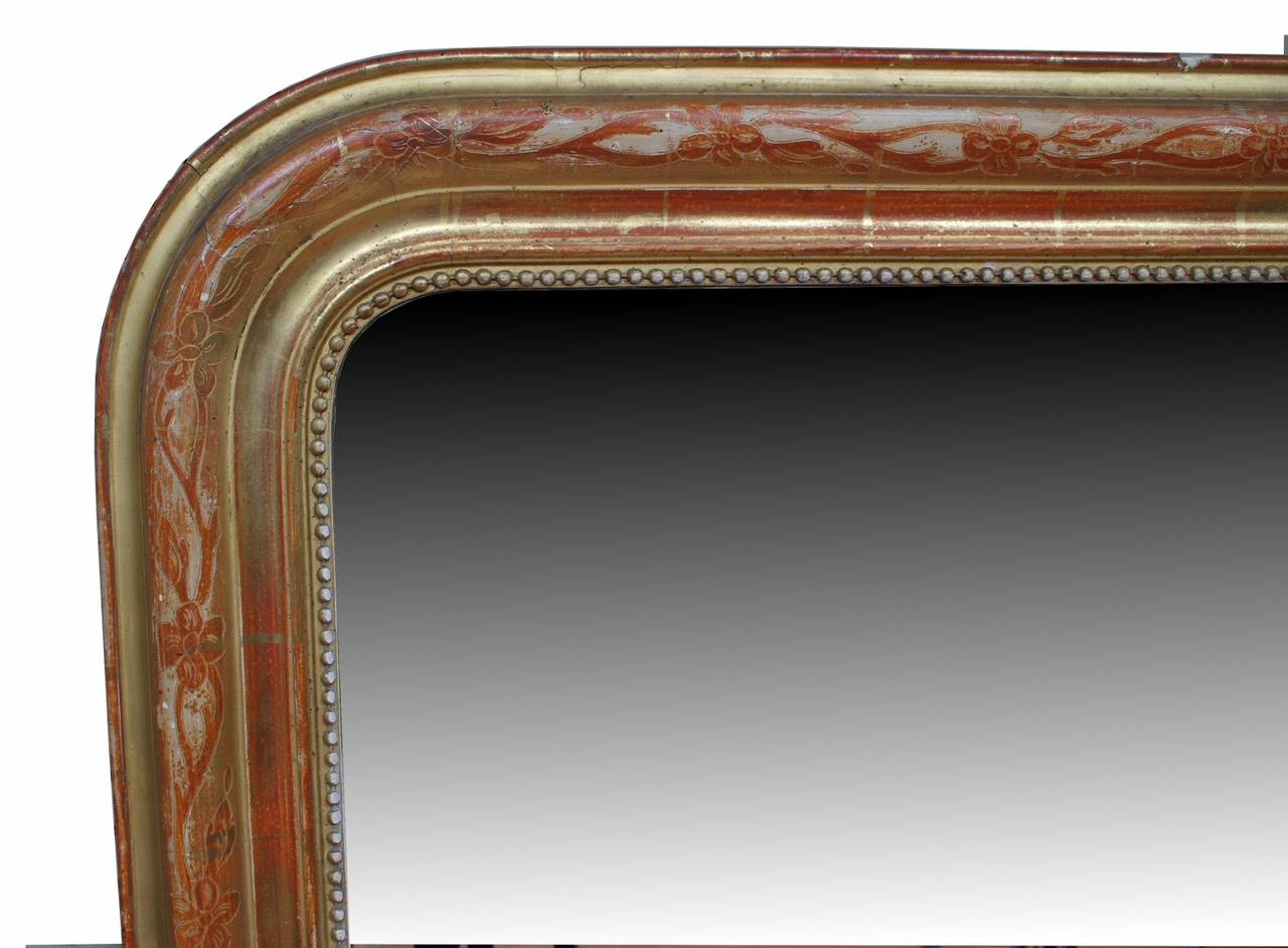 Louis Philippe giltwood mirror, the rounded molding with incised leaf and flower decoration and beaded edge, the water gilding well-worn into the red bole. Mirror replaced.