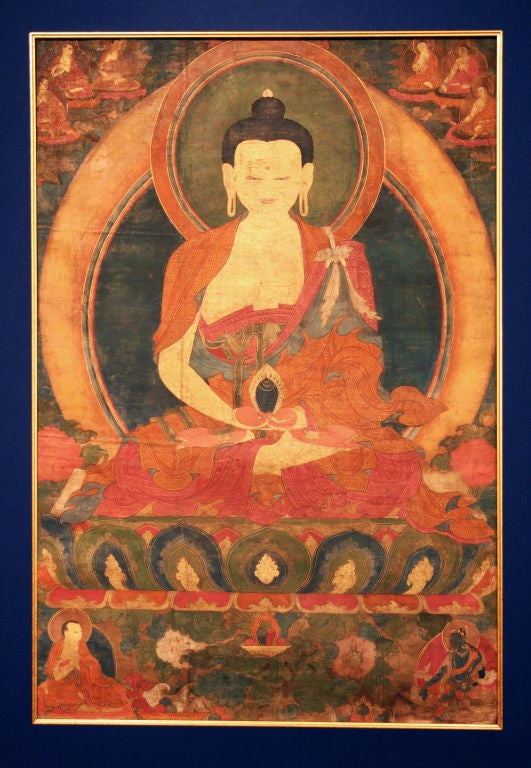 A fairly large image of a noble, golden Buddha holding a Cintamani (Wish-fulfilling Jewel) in his hands, which are arranged on his lap in the Dhyana mudra (gesture of meditation). He is seated on an elaborate lotus throne with a triple-jewel