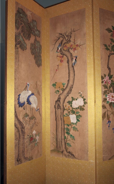 A beautifully painted, tall folding screen featuring avian and botanical motifs.