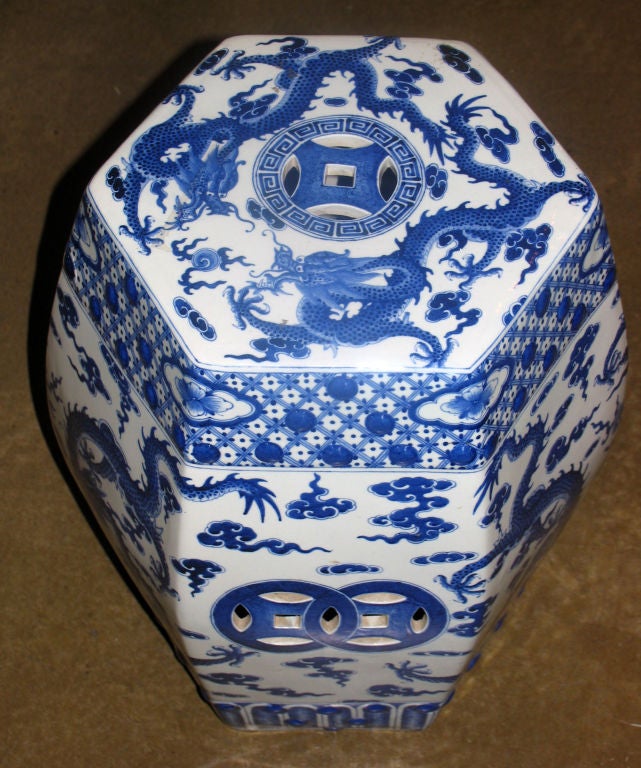 Vibrant handpainted blue and white chinese porcelain garden seat of hexagon shape depicting 5-claw dragons symbolizing royalty within geometric borders with raised buttons.