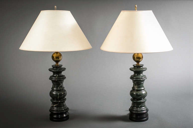 Pair of neoclassical style turnwood and faux marble painted lamps with brass ball on the top portion.
Measure: 23 and a half inches to the top of the socket.