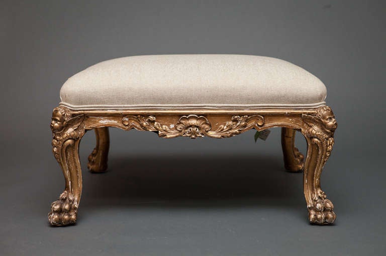 Continental large gilded stool angel face 
on top of each leg ending in paw feet.  
Upholstered with fabric with flower 
motif.  27
