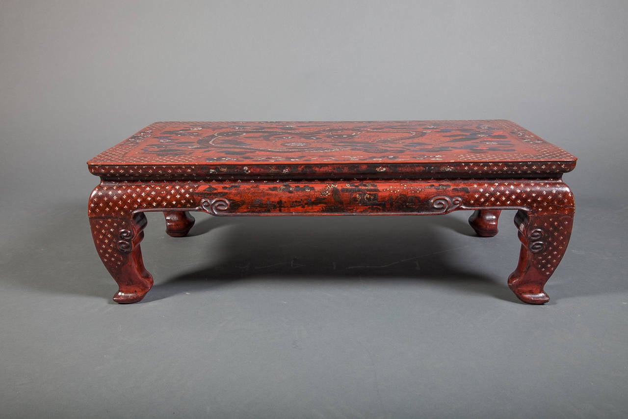 Table chinoise en laque rouge du XVIIIe siècle avec incrustation de coquillages et motif de dragon.