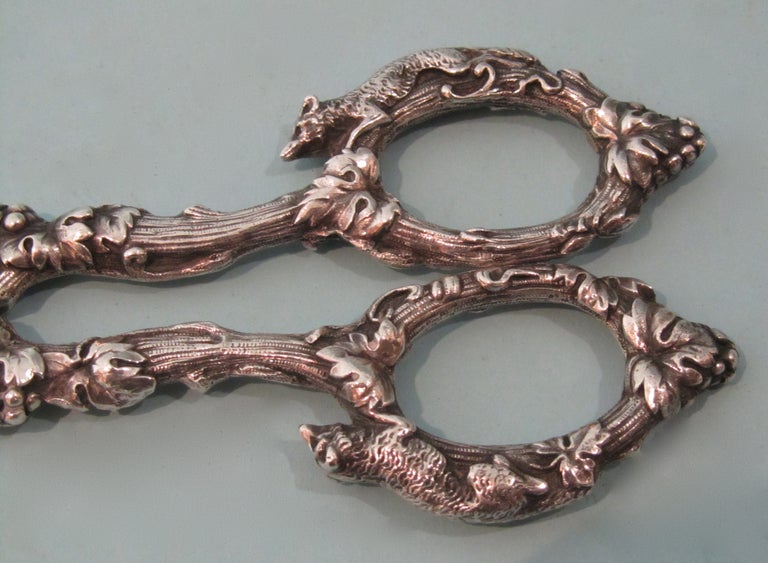 A good sterling silver grape scissors - shears by the Gorham Company decorated overall with grapes, leaves and cast foxes on the handles. Faint monogram ECR.