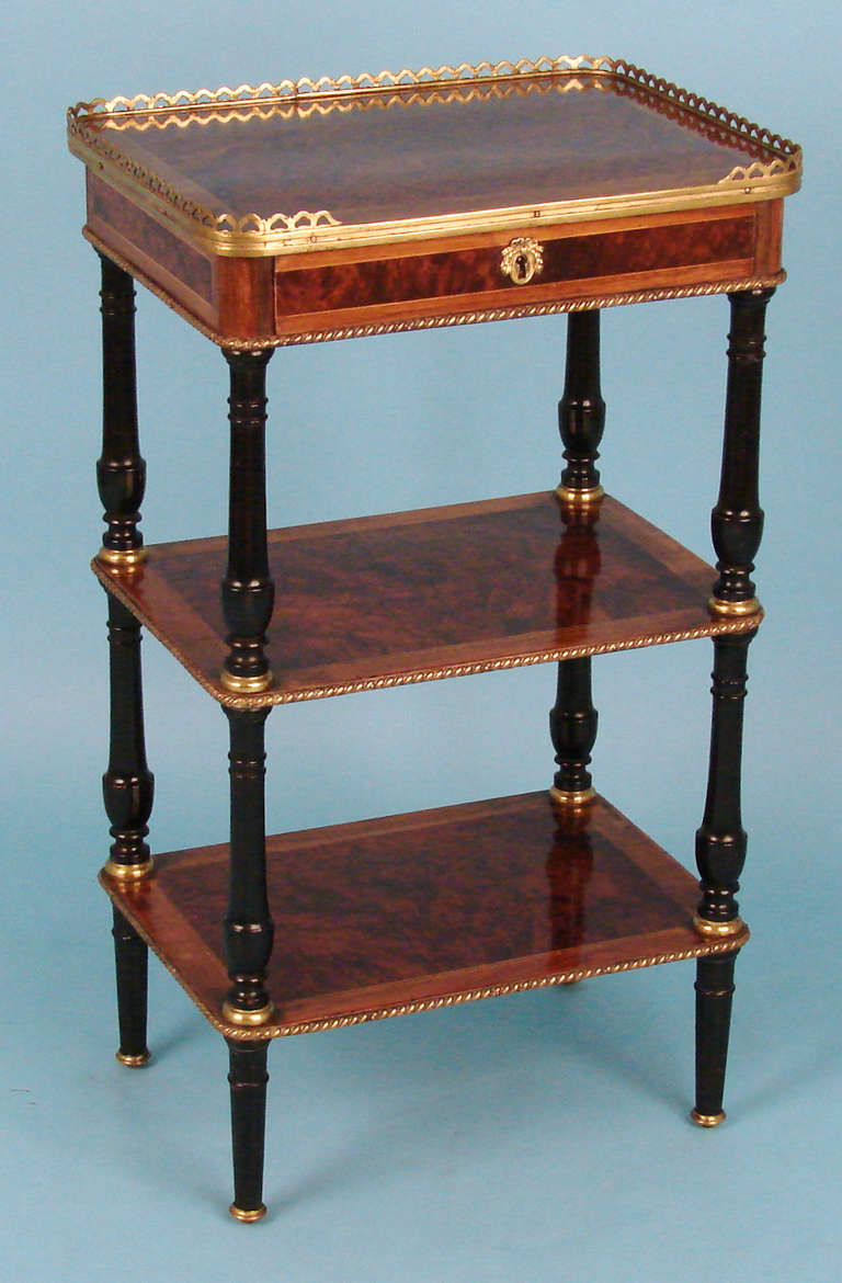 A pretty French Napoleon III period 3 tier etagere, the top with an ormolu gallery above a single drawer above 2 further gilt metal mounted shelves supported by well-turned ebonized legs. Lock signed 