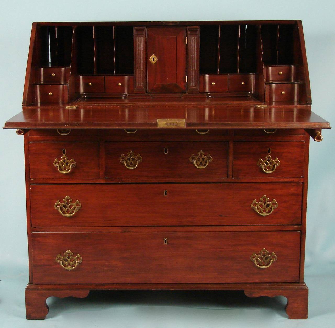 A good quality English Chippendale period mahogany slant front desk, the well-fitted and shaped interior above three short and two long drawers supported on bracket feet, circa 1770.