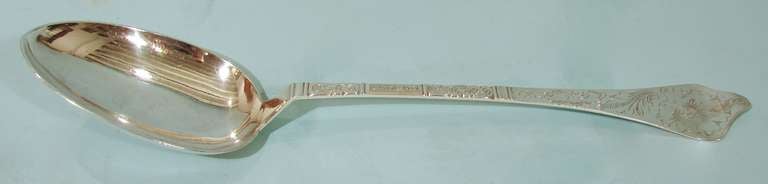 An engraved sterling silver serving spoon of large scale with unidentified European hallmarks.