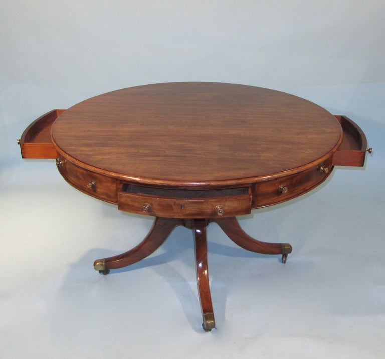 An attractive Regency mahogany figured mahogany drum table, the  revolving solid well-figured top with moulded edge above 4 false and 4 working drawers, one fitted with a writing slope and compartments,  mounted on a quadripartite base ending in