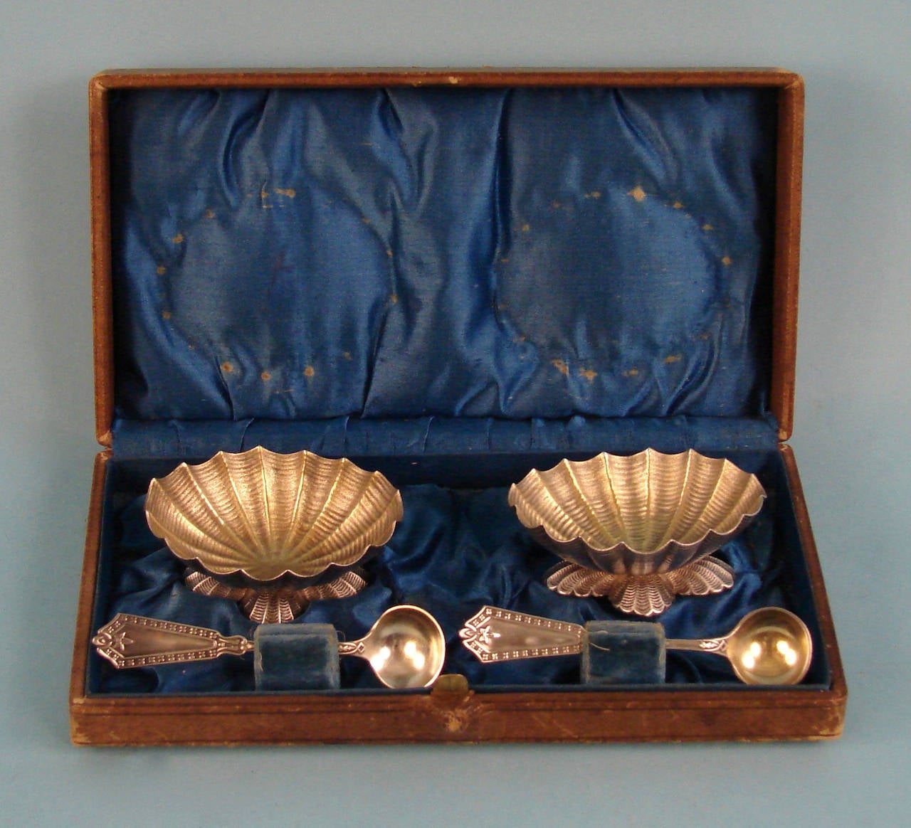 A pair of American late 19th century cast silver gilt open salts (with spoons) in the form of clam shells, made by the Frank Whiting Company retaining their original leather satin lined case. Marked 