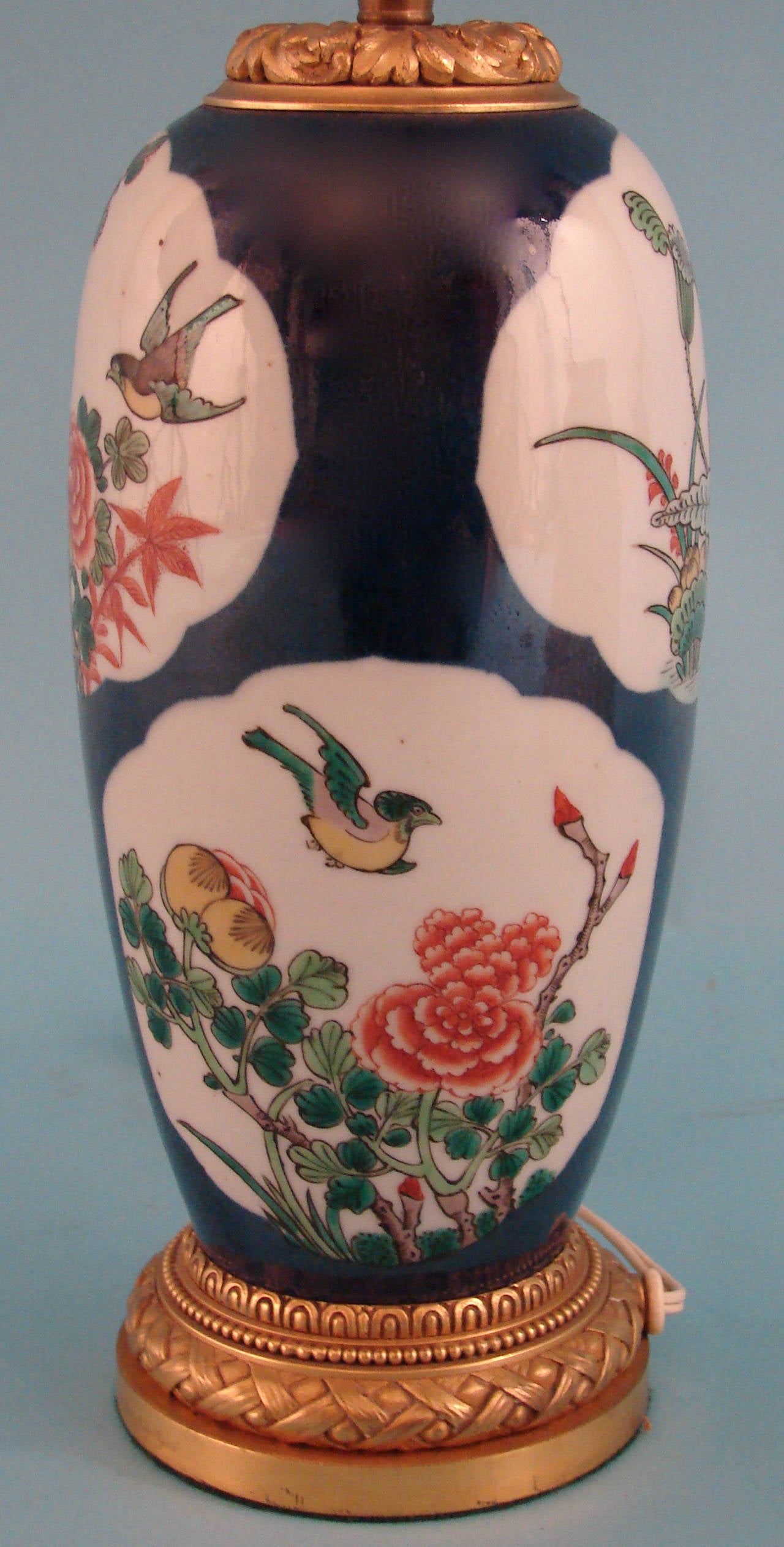 An early 20th century Chinese export famille blue porcelain vase decorated with flowers and birds, now with gilt metal mounts and electrified. Custom silk shade.