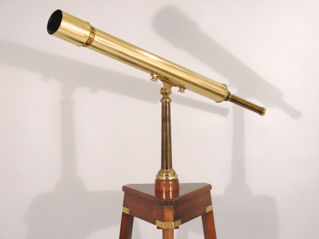 An English brass telescope made and signed by E. ELLIOT/TELESCOPE HOUSE, 63 FARRINGDON RD., LONDON E.C.on later triangular mahogany stand. (Previously sold Christie's New York $4780 1-15-03).