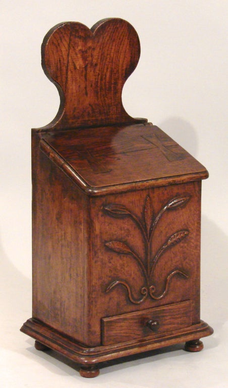 A mid-18th century Louis XV walnut pipe box, the heart shaped top above a slanted hinged cover over conforming case carved with a spray of wheat above single drawer, all on outstepped base with four pad feet, the reverse fitted with iron hanging