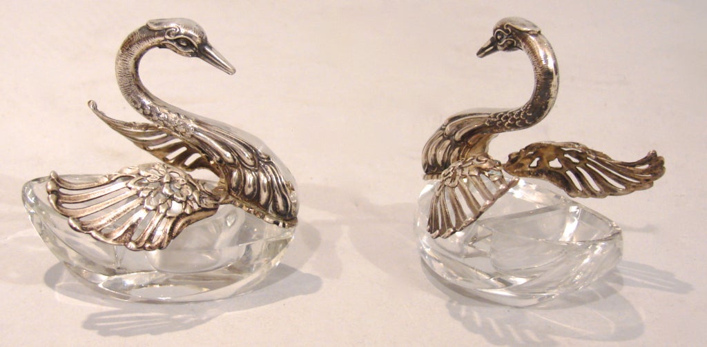A pair of Continental crystal and sterling open salts in the form of swans with moveable wings complete with spoon. Made by Carlo Mario Camusso, Lima Peru.