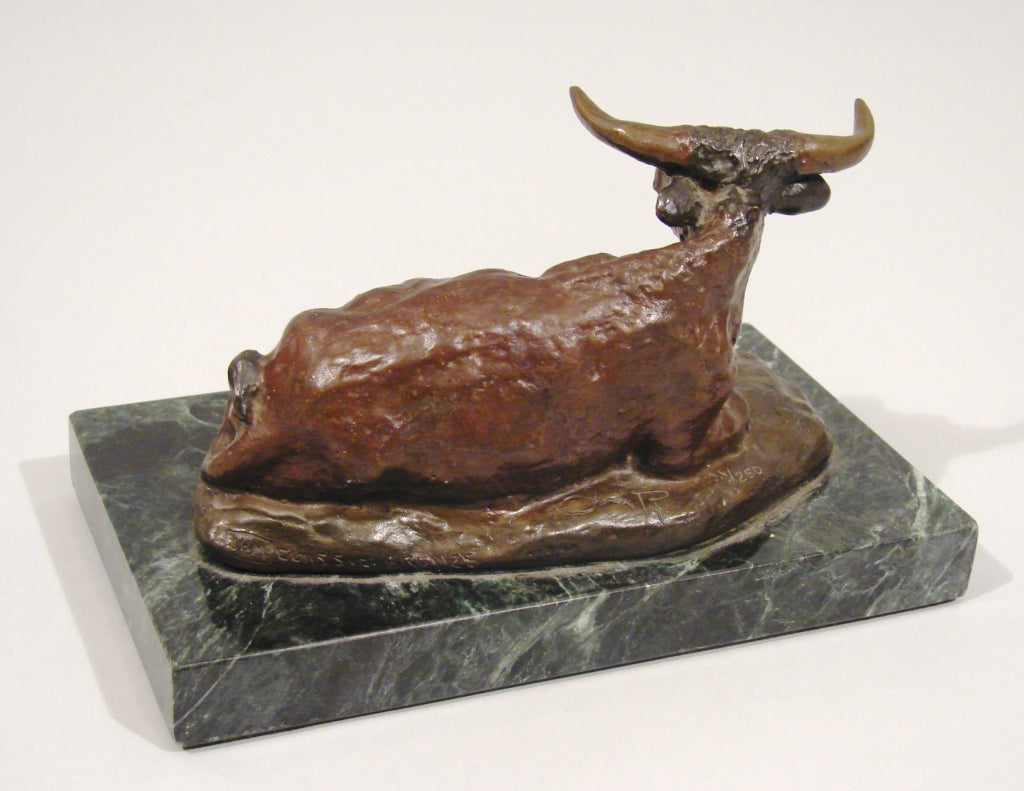 Cast after Charles Marion Russell (American 1864-1926.) A patinated bronze study of a recumbent steer, incised CM Russell, symbol of a cow head, 1926, JHM. CLASSIC BRONZE, CMR, 1/250.