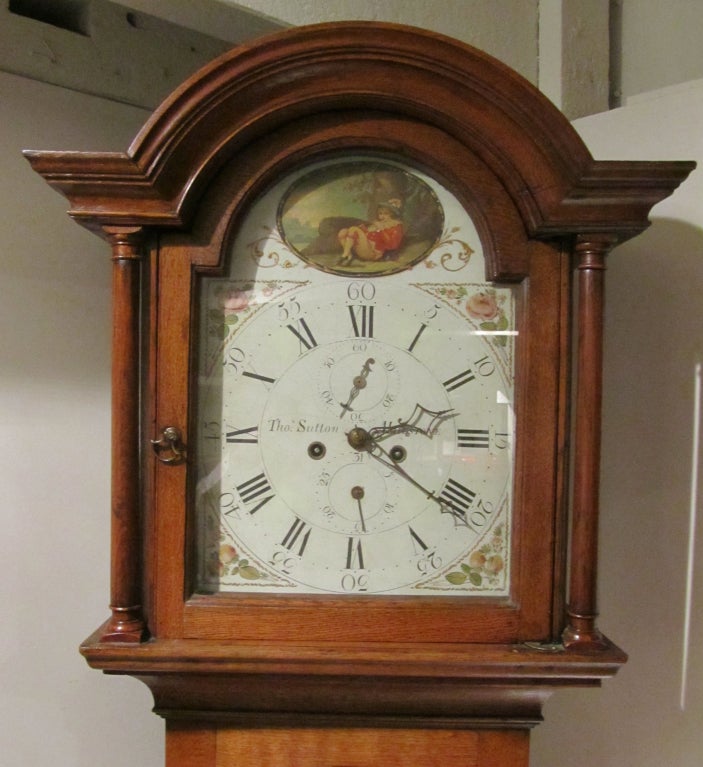 An English oak arch top long case clock with painted dial and 8 day movement by Thos. Sutton of Maidstone (listed in Britten's as working circa 1800). Replaced plinth. In good running order.