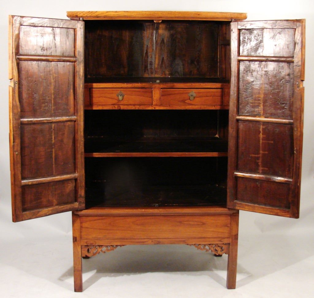 An attractive Chinese hardwood 2 door cabinet of traditional form with applied metal hardware, the interior fitted with 2 drawers over a shelf above a hidden compartment. Originally sold by Gump's San Francisco.