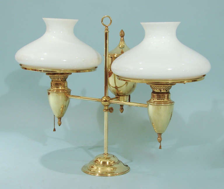 An American brass double students' lamp made and signed by Bradley & Hubbard with replaced white cased glass shades, now electrified. Signed underneath 