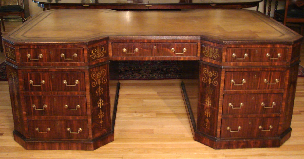 A beautiful and important English Regency style brass inlaid partners desk, the shaped inset gilt-tooled leather top above three frieze drawers on each side, the reverse with cabinets below, the front with 6 additional drawers, the corners with