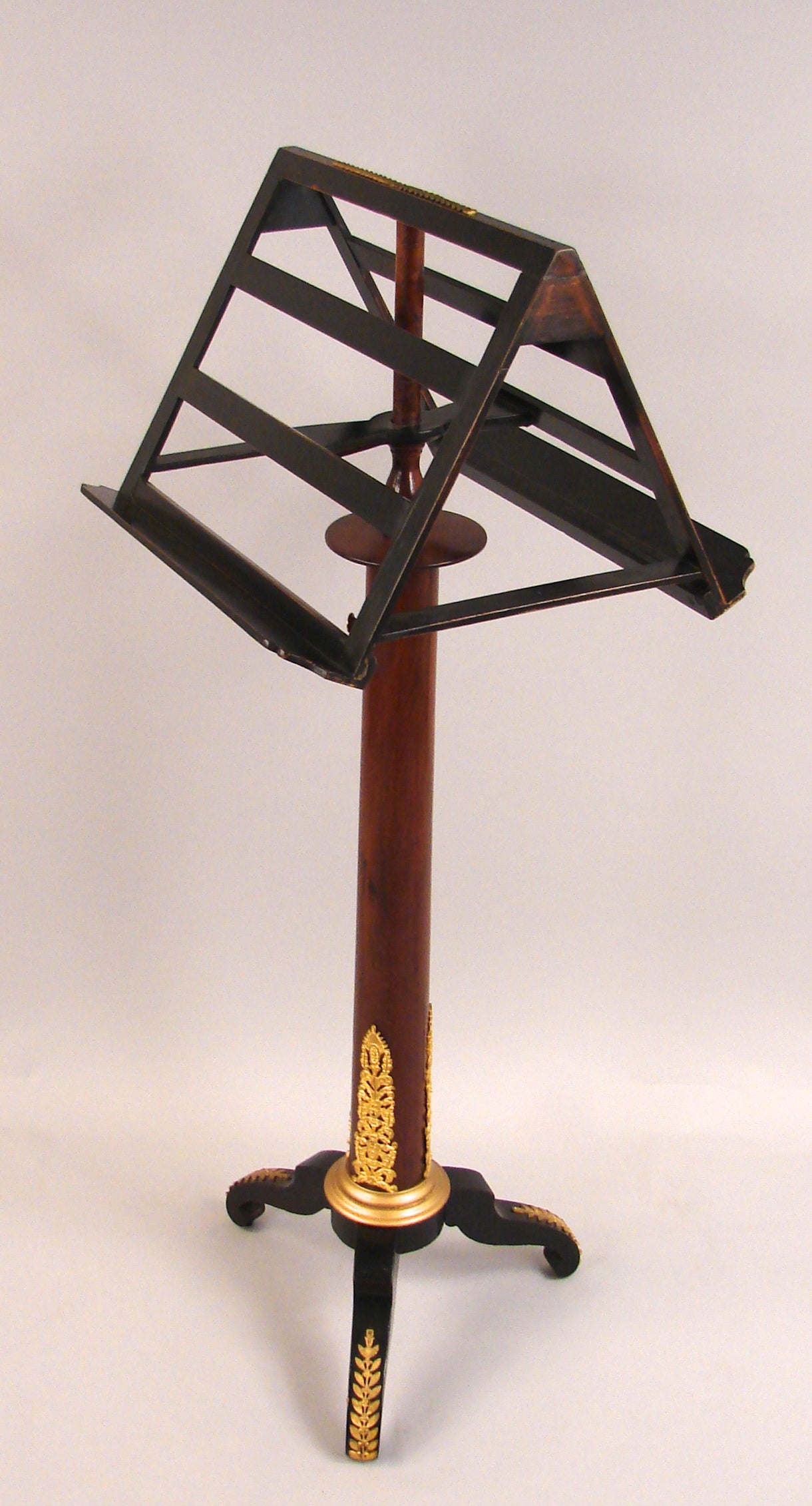 A French Empire style mahogany ormolu-mounted adjustable duet music stand, the revolving ebonized sheet music holder above a tapering ormolu-mounted mahogany standard ending in an ebonized tripod base, circa 1870.