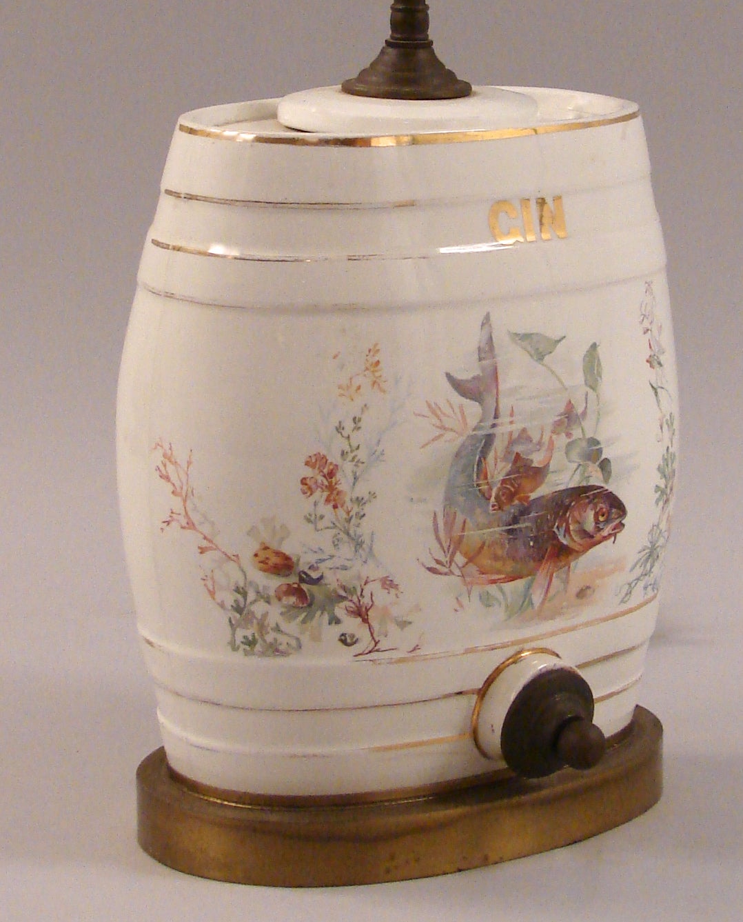 An English 19th century porcelain gin barrel depicting a lively trout in an underwater floral setting, now mounted as a lamp, circa 1875.