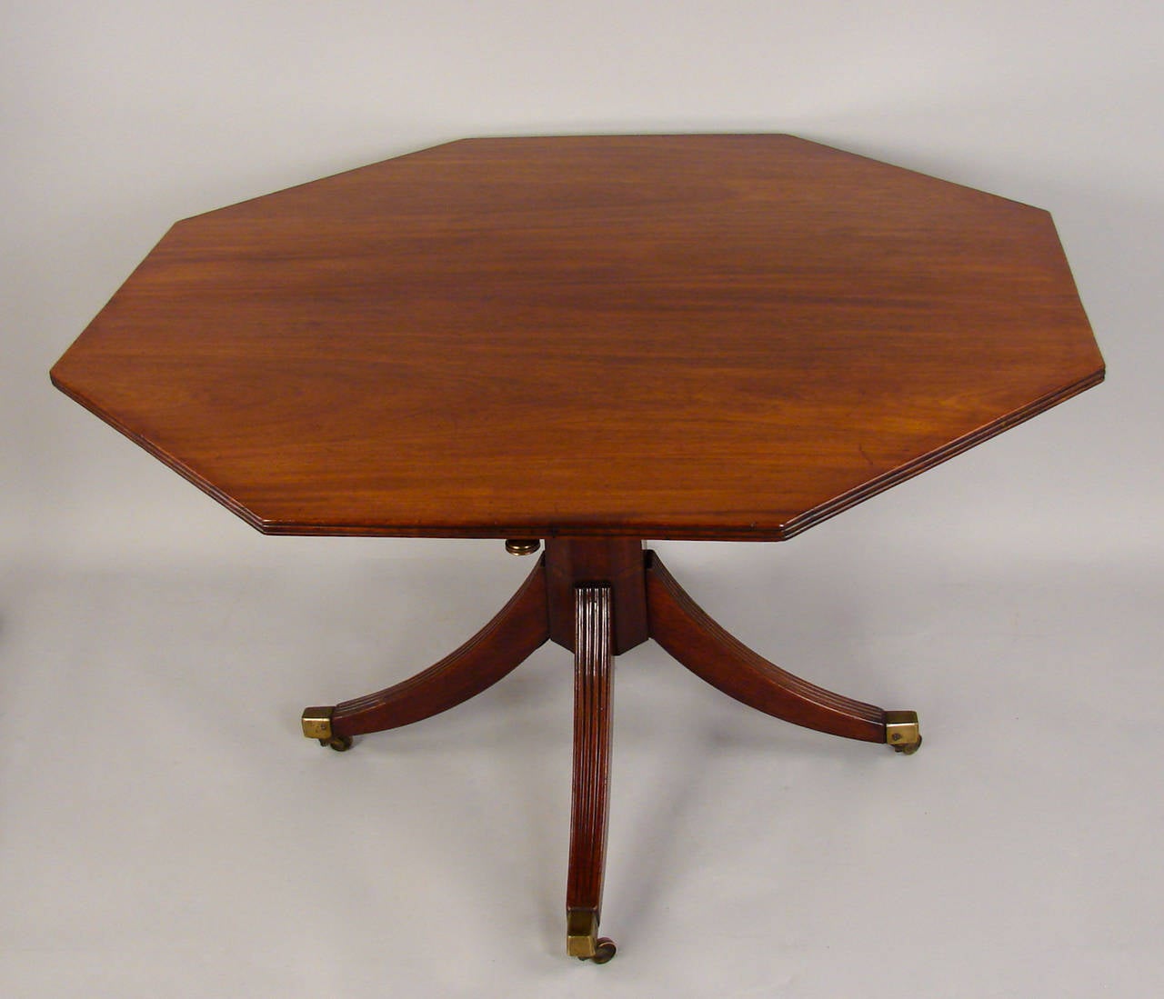 A good quality early Regency centre table, the octagonal top with a reeded edge supported by a tapered eight-sided central support terminating in a down swept reeded quadripartite base ending in box casters, circa 1800.