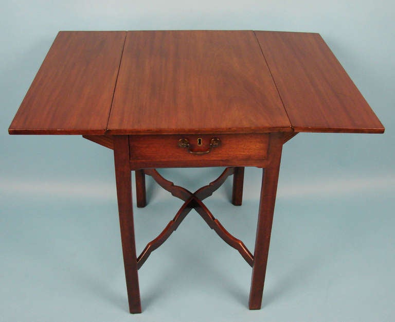 An attractive small scale English George III period mahogany pembroke table, the overhanging top above a single drawer, the legs joined by a shaped x-stretcher.