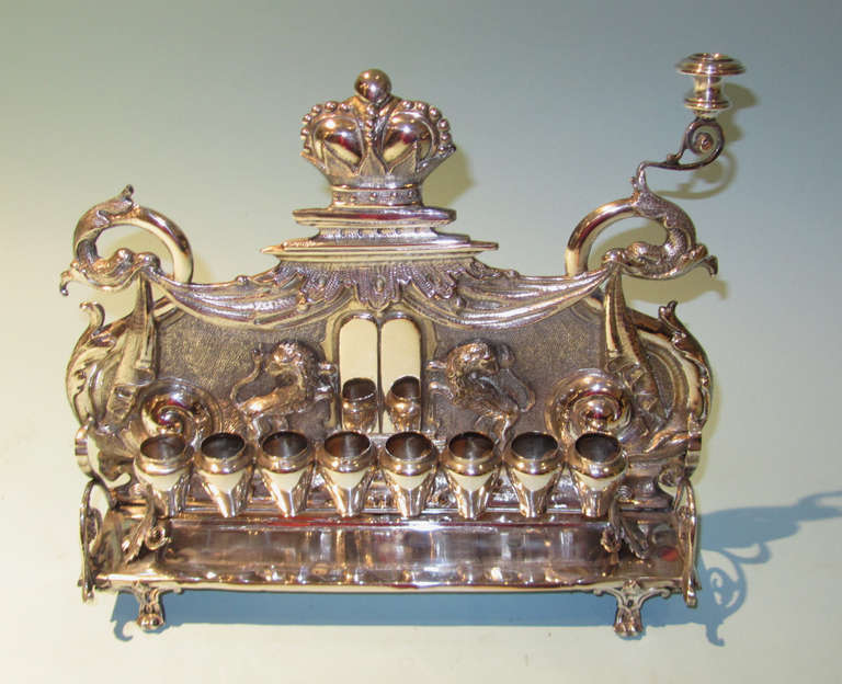 An Austrian or Eastern European silver Hanukah lamp (menorah) the back plate with a crown centering the 10 commandments, flanked by lions with draping held by eagle heads. Hallmarked in multiple places, circa 1880.