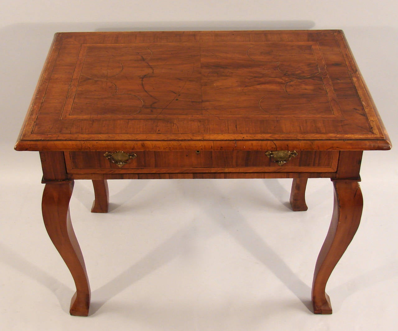 A Queen Anne Provincial walnut side table, the line inlaid overhanging rectangular top with a molded edge above a single-drawer supported on cabriole legs, circa 1730-1750.