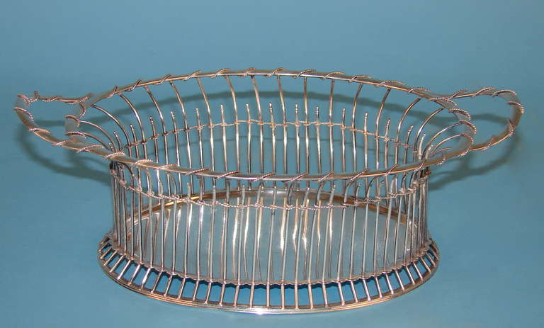 An interesting and unusual English sterling silver oval basket with delicate silver ropework wrapping the rim and handles, hallmarked for London 1898-1899, maker's mark WC.