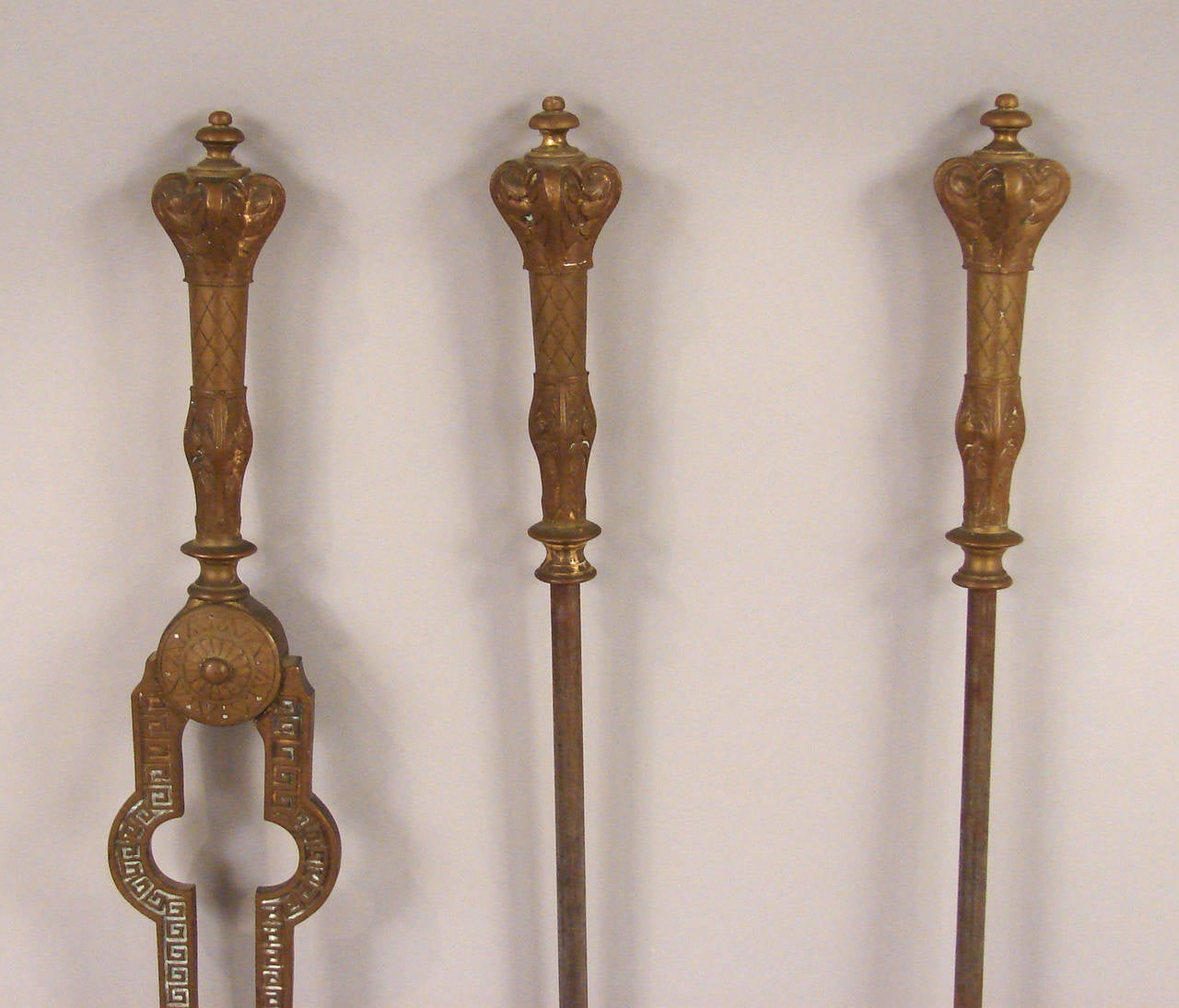 A set of English Victorian brass and steel fire tools consisting of a shovel, poker and tongs, circa 1880.