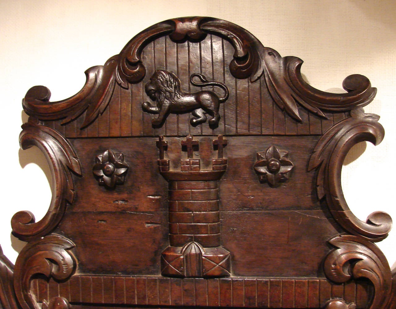 A wonderful carved walnut plaque of large size depicting a lion rampant above a castle flanked by stylized roses with draped flags on the sides all above a quote from Shakespeare's Henry VIII 