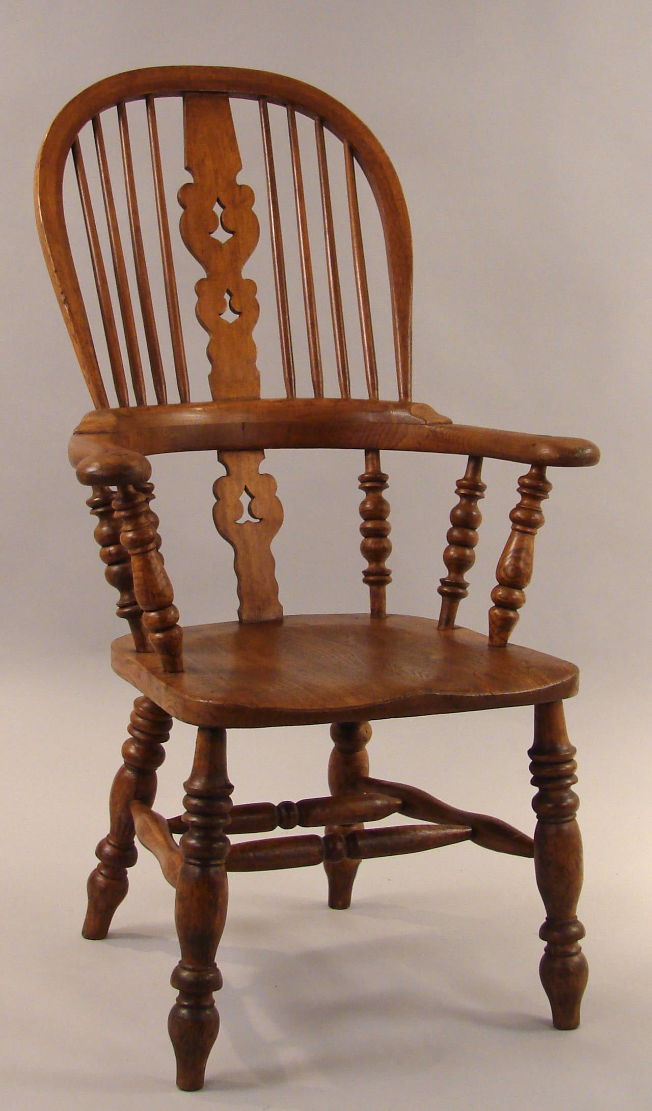 An assembled set of 6 elm and hickory English broad arm high back Windsor armchairs each with Christmas tree splats and turned 