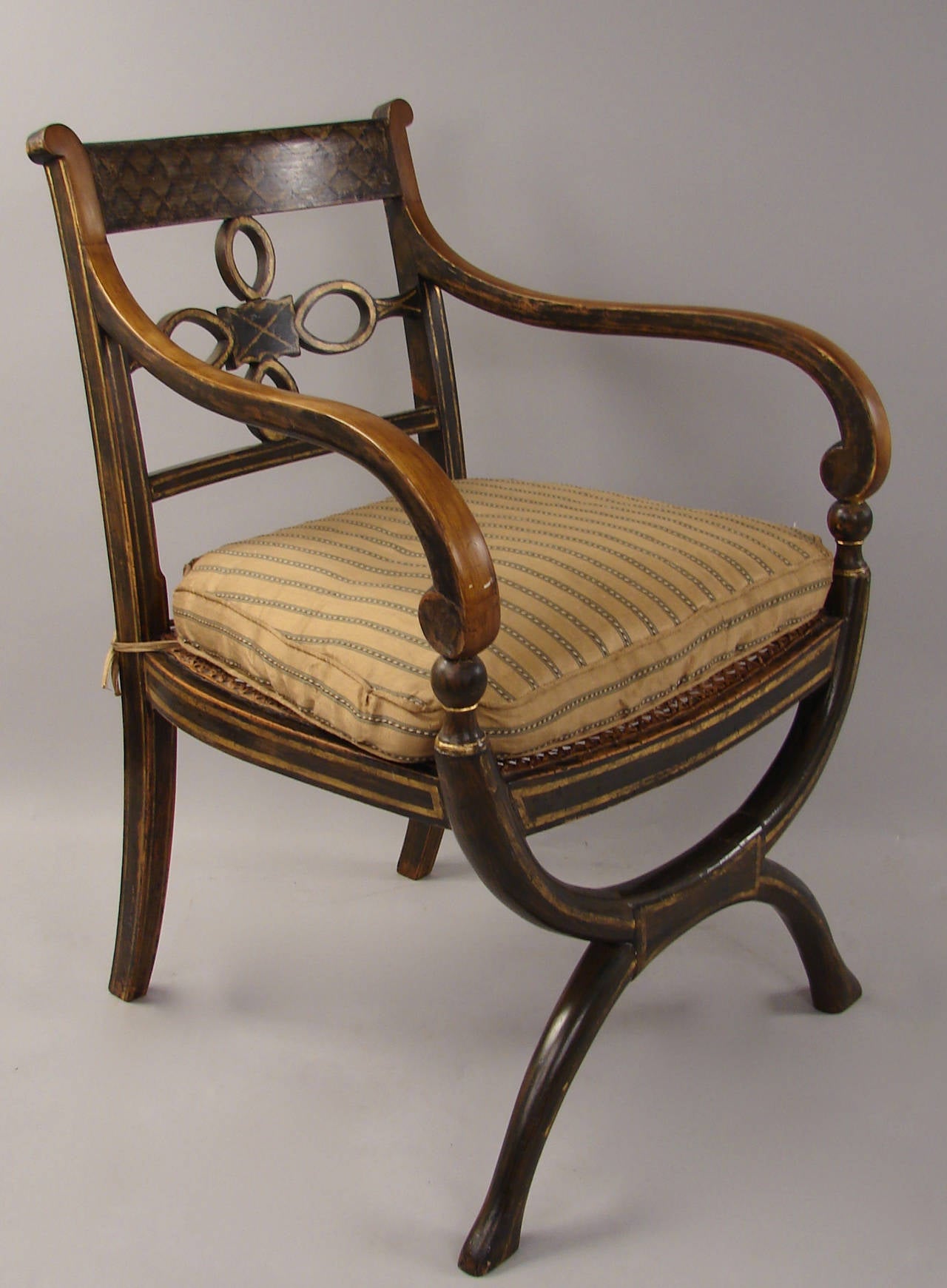 A painted and parcel-gilt Regency armchair of Curule form, circa 1820.