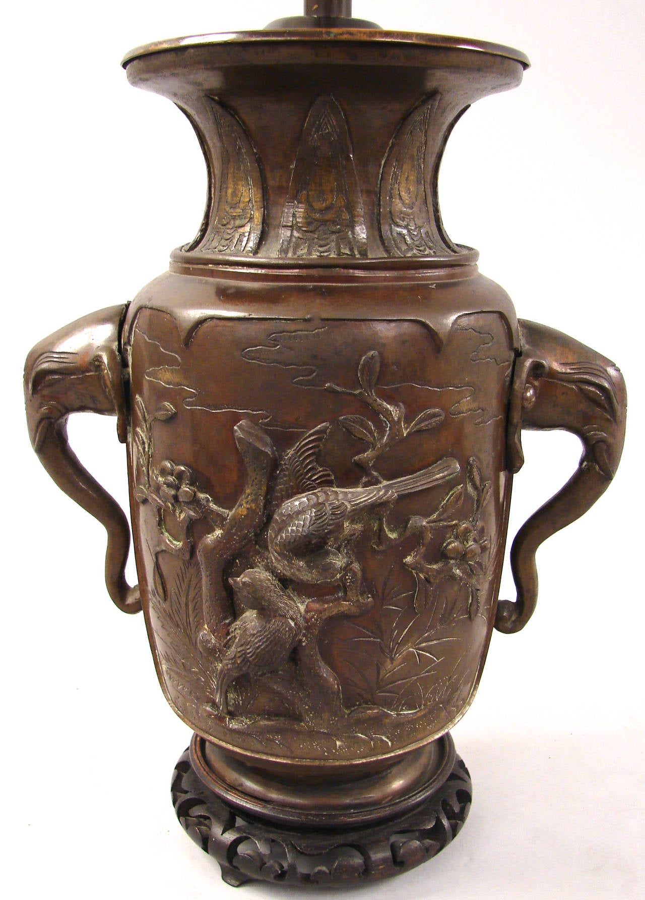 A Japanese bronze of the late Meiji period with elephant head handles and cast birds and flowers in relief. Now electrified and mounted as a lamp. Vase circa 1880-1900.