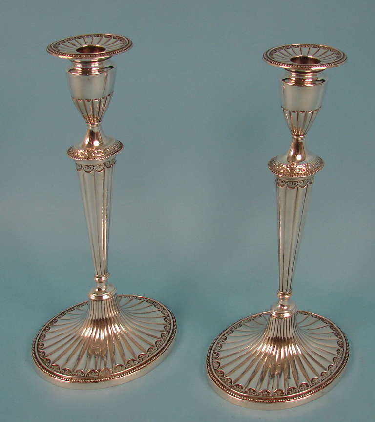 A pair of American sterling silver candlesticks in the Adam taste complete with their original bobeche, manufactured by the Gorham Silver Company, circa 1915.