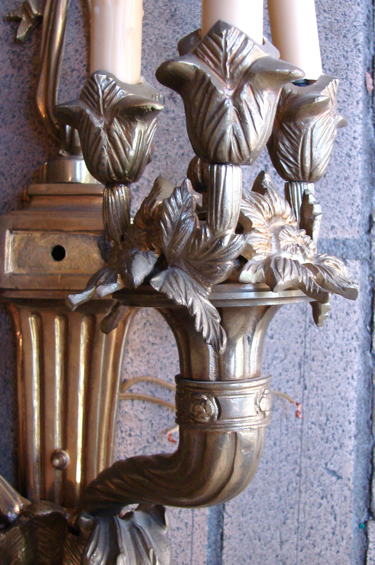 An impressive large-scale pair of French Louis XVI style gilt brass two-arm six-light wall sconces, circa 1920. These sconces came from an important San Francisco home and were probably original to the structure.