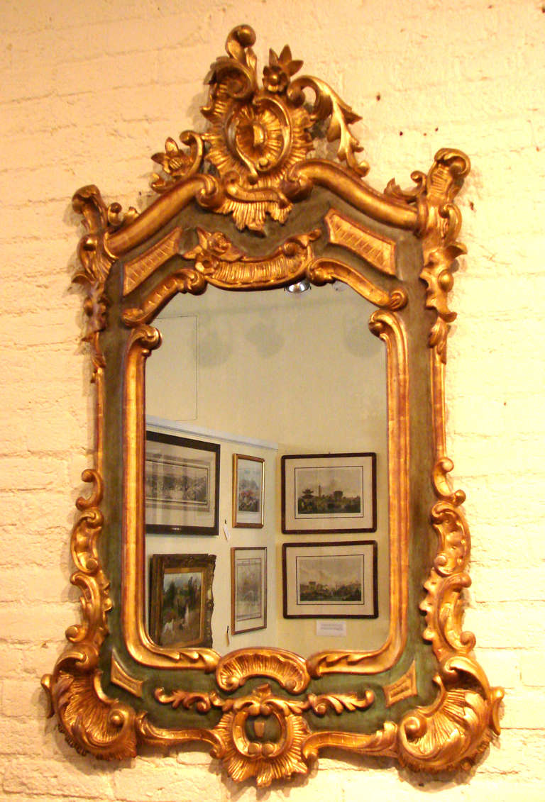 An attractive 18th century continental (probably Italian) Rococo giltwood and green painted mirror, the scrolled frame with a well-developed crest and overall foliate decoration. Purchased in Spain in 1965.