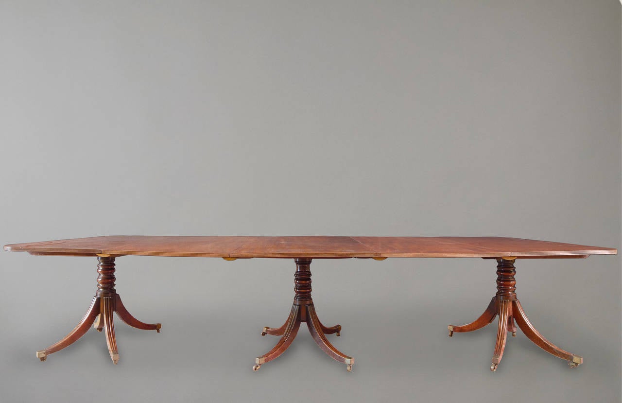 A good quality Regency period mahogany three pedestal dining table, the well-figured and matched top with a reeded edge over turned supports ending in reeded quadripartite pedestals with brass casters. Retains two original leaves,
circa 1800-1810.
