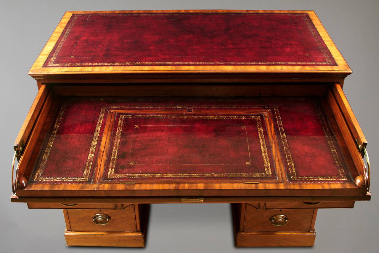 A fine quality Regency mahogany architect's desk, the double-ratcheted leather lined top (it can be raised in either direction) enclosing a second leather lined retractable surface with a reading slope, over six inlaid lidded compartments inset with