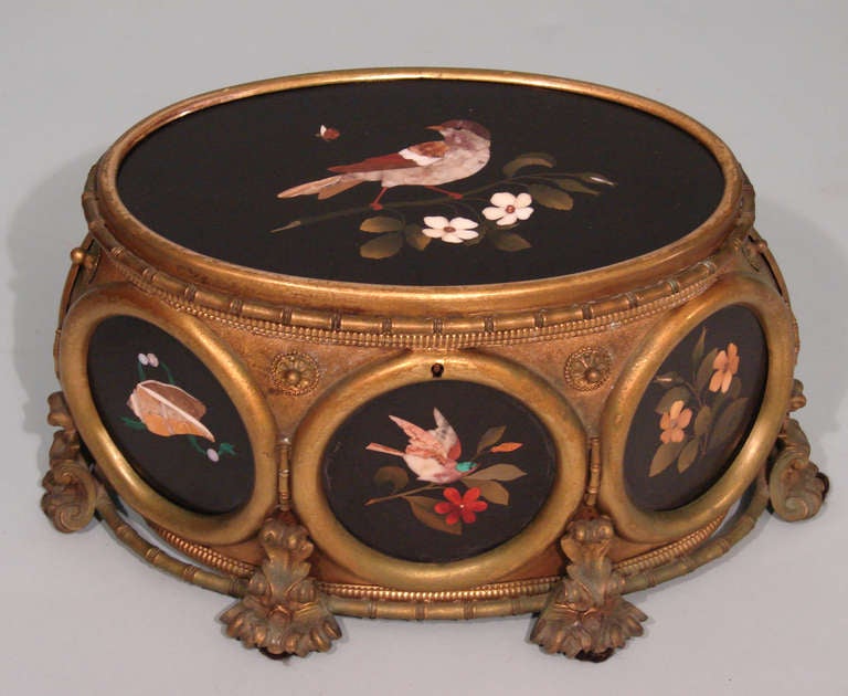 An Italian oval gilt bronze box mounted with six oval pietra dura plaques, the hinged top similarly mounted the interior lined in velvet. Circa 1880. One plaque with small hairline crack.