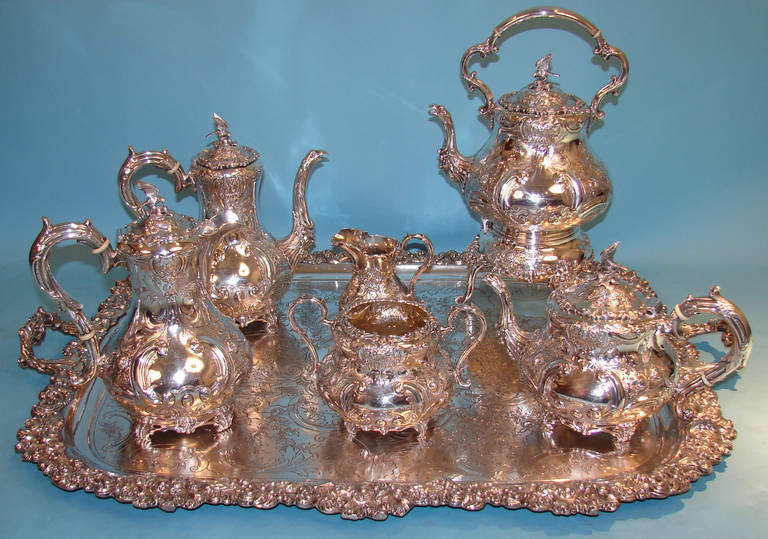 A high quality six piece English sterling silver beverage service with foliate repousse design and cast bird finials consisting of a coffee pot, teapot, chocolate pot, kettle with heat source, creamer and waste bowl. All pieces fully hallmarked and