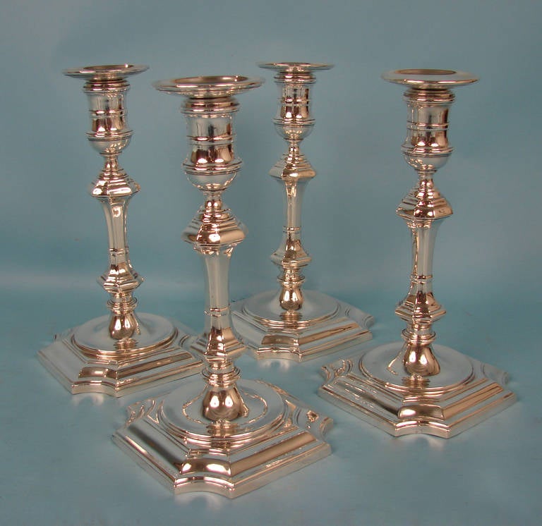 A fine set of four George II style sterling silver candlesticks, complete with detachable bobeche, made and signed by Currier and Roby (New York 1900-1943). Weighted.