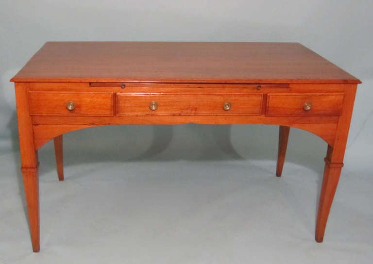 An attractive Neoclassical period Italian walnut writing table, the top with a molded edge above two short and one long drawer, with a pull-out writing surface over the center drawer and the back finished with false drawers, circa 1790.