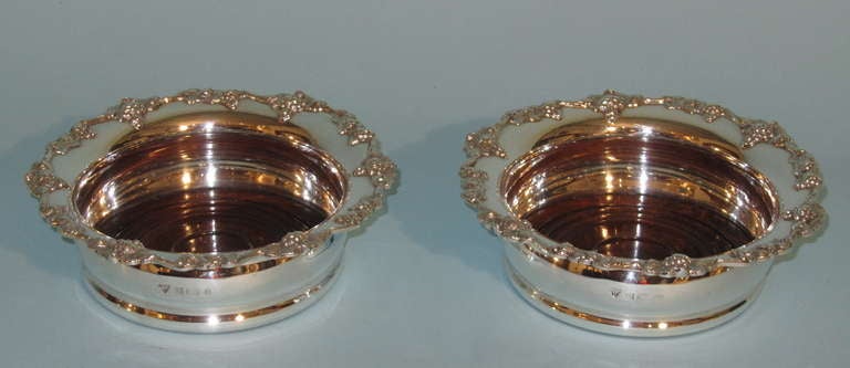 A pair of Elizabeth II sterling silver and walnut wine coasters by Garrard  and Company Ltd. Birmingham 1981. Fully hallmarked.