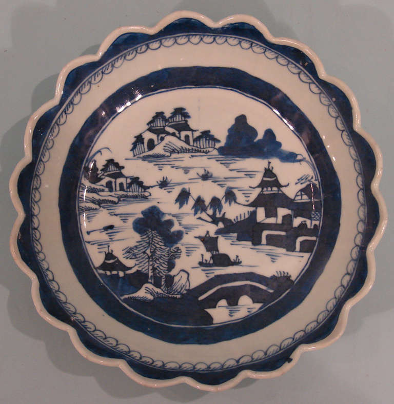 A pretty Canton blue and White scalloped edge bowl typically decorated with buildings, boats and bridges, the scalloped edges with interior banded decoration.