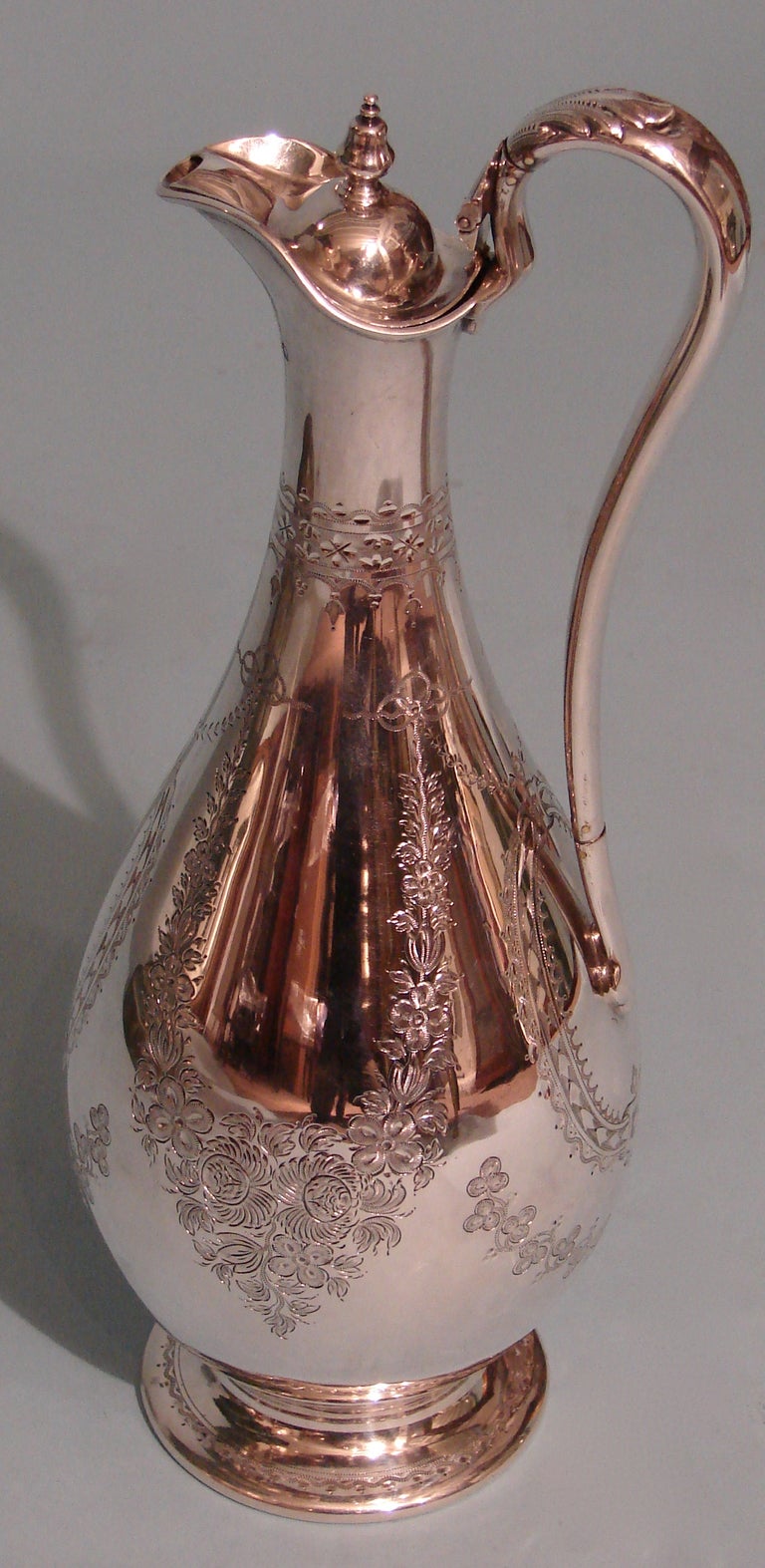 A good sterling claret jug of elegant pear form design, with a long slender neck ending in a collared rim.  Interior gilded. Made by Martin Hall & Co., Sheffield, 1868. Weight 22.78 troy oz.