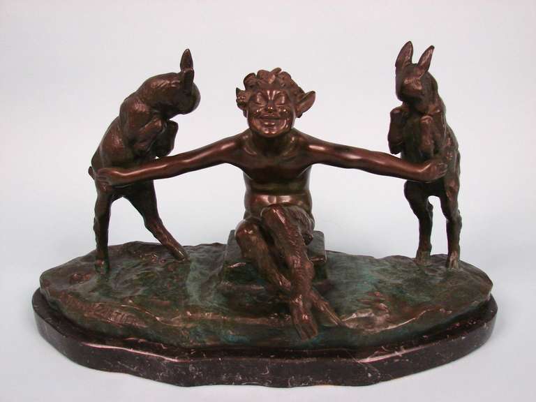 An interesting and amusing verdigris patinated bronze group depicting a smug satyr restraining a pair of goats all on a naturalistic ground, raised on a black marble base. Signed 