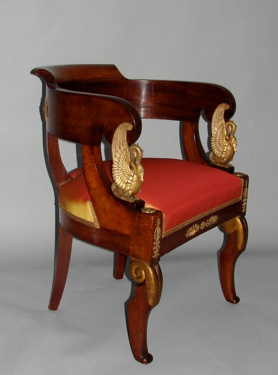 A French Empire style mahogany bronze mounted fauteuil de bureau the arms with well cast bronze swans, the chair further embellished with additional elegant bronze mounts.