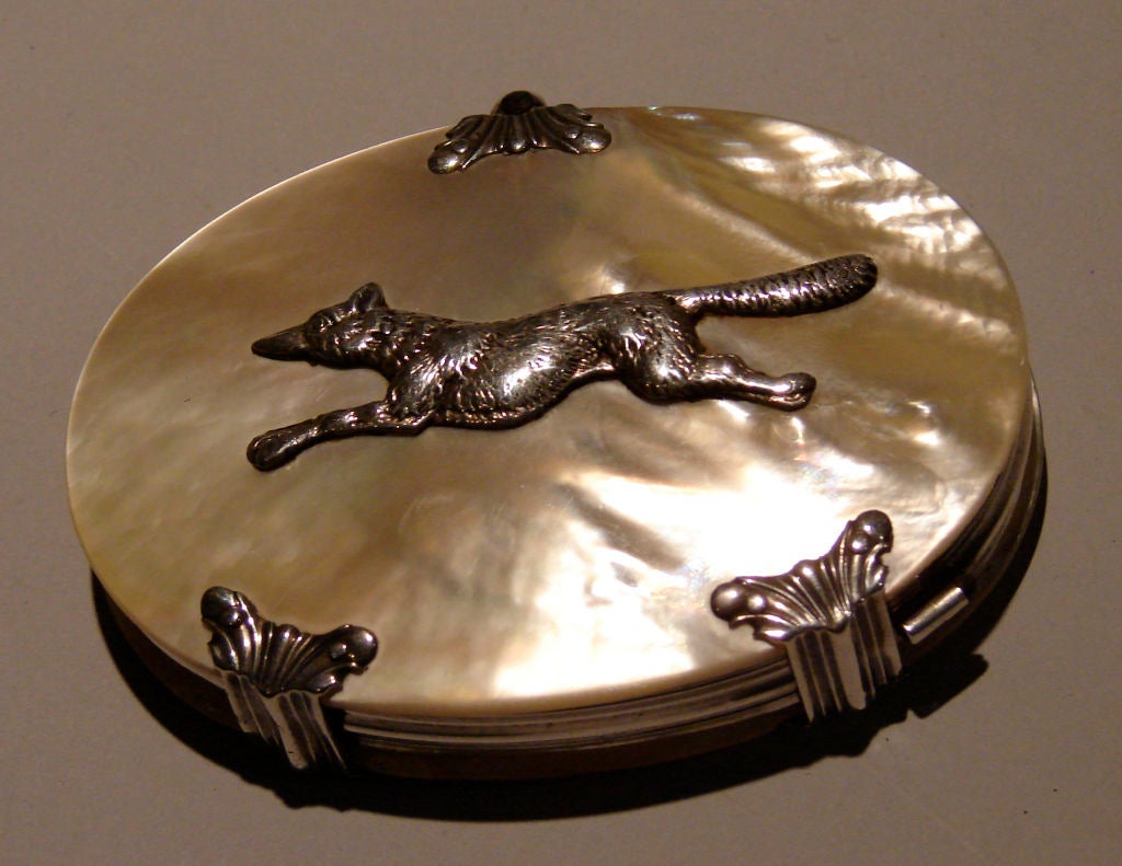 A rare and beautiful English oval silver mounted mother of pearl case, the exterior with a cast silver fox, concealing a silver framed magnifying glass. Circa 1880.